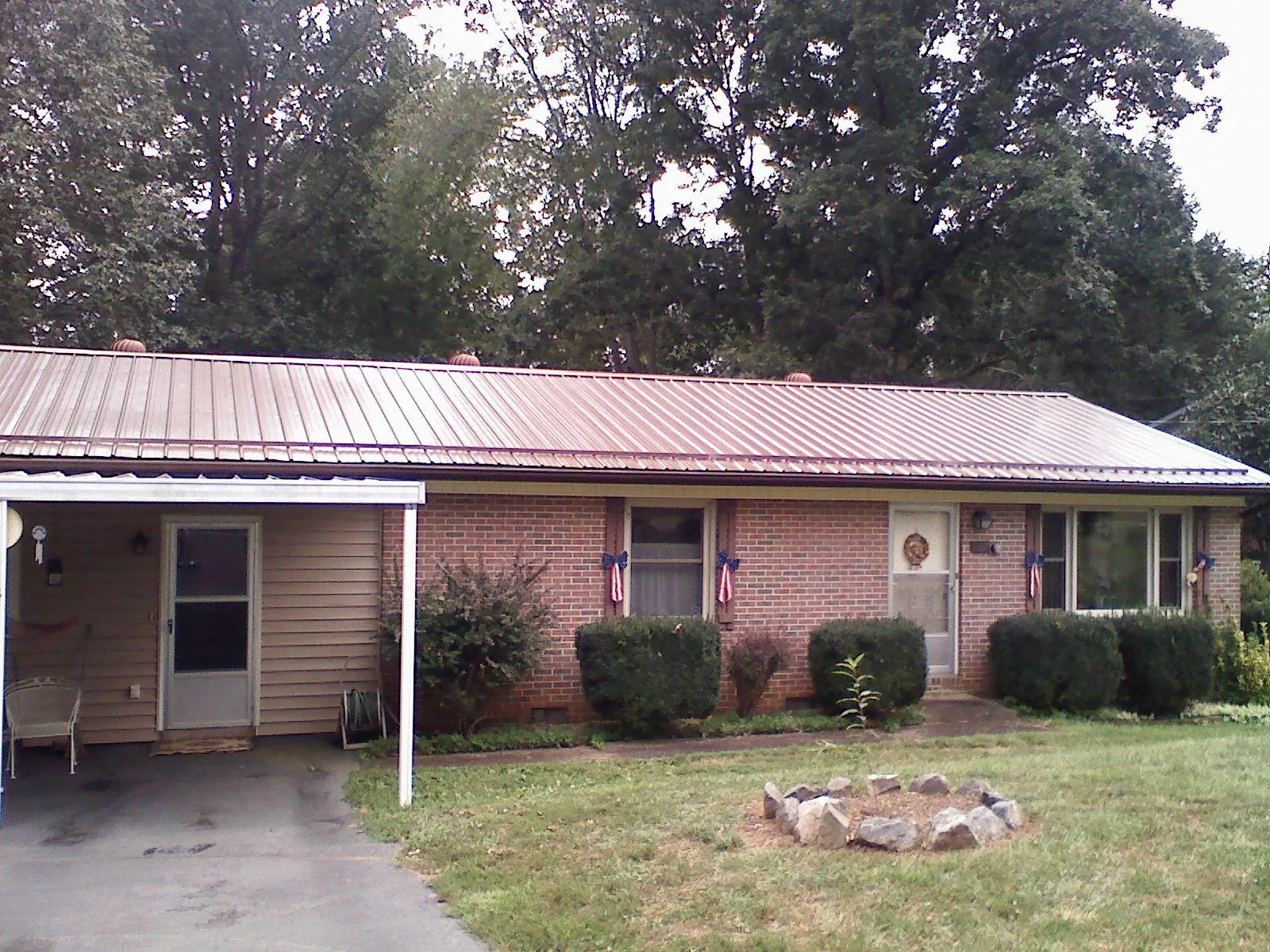 Bronze metal roof and carport on a brick ranch home — Roof Repair work by our crew in Eaton Park